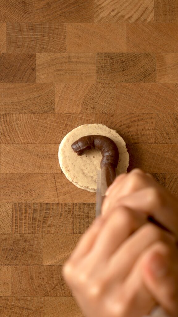 piping custard onto the back of a merengue