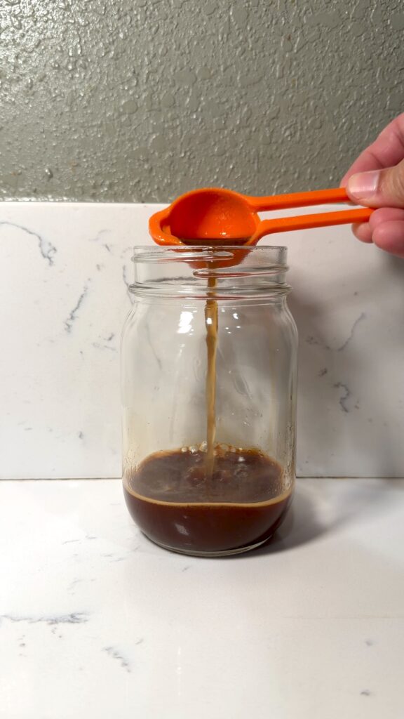 adding banana bread syrup to a shot of espresso
